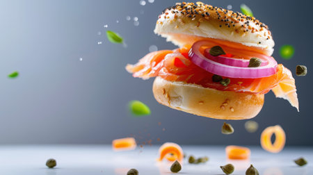 A visually striking image of a fresh bagel topped with lox and red onion, accented with capers, captured mid-air against a soft gray background.の素材