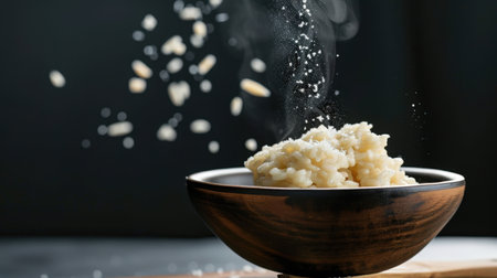 A delicious creamy risotto served in a wooden bowl, garnished with grated cheese and pine nuts, exuding warmth and comfort for food lovers.の素材