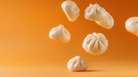 A collection of freshly steamed dumplings floating in mid-air against a vibrant orange background, perfect for showcasing culinary creativity and delicious recipes.の素材