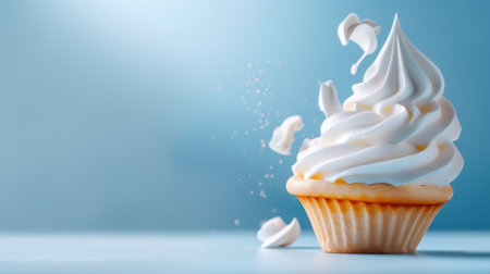 A beautifully crafted cupcake topped with fluffy whipped cream sits on a soft blue background, evoking feelings of sweetness and joy in every bite.の素材