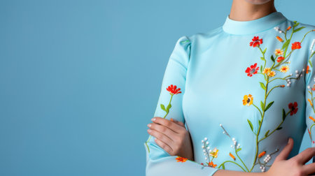 A striking image of a model showcasing a blue dress with vibrant floral embroidery, emphasizing elegance and modern style in fashion photography against a soft backdrop.の素材