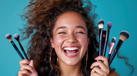 A joyful young woman showcases her makeup brushes with a vibrant turquoise background. Her radiant smile and lively personality capture the excitement of beauty routines.の素材