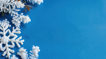 A serene and artistic composition featuring frosty snowflakes alongside pine leaves on a vivid blue background, ideal for winter-themed projects.の素材