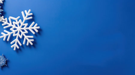 This image features white snowflakes arranged on a vibrant blue background, perfect for conveying winter themes and festive decorations in various designs.の素材