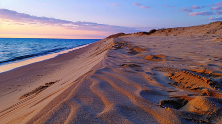 Experience a tranquil coastal landscape captured during sunset, showcasing gentle waves lapping against sandy shores under a colorful sky.の素材