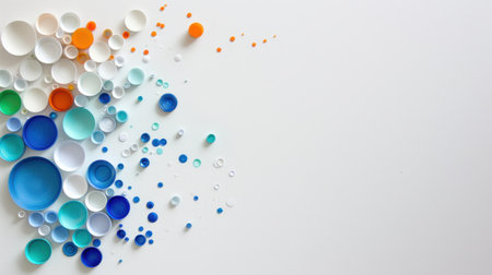 An artistic display of various sized plastic caps and circles in vibrant hues, arranged dynamically on a bright white background, ideal for creative projects.の素材