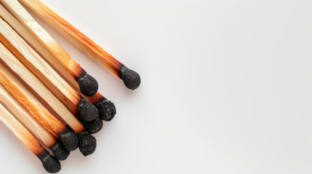 A striking image showcasing a group of wooden matches with darkened tips against a minimalist background, perfect for creative or editorial use.の素材
