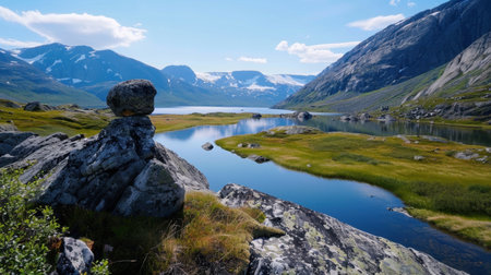 Discover a serene mountain landscape featuring a calm lake surrounded by rocky shores and lush meadows. Bright skies and picturesque scenery create a perfect outdoor getaway.の素材