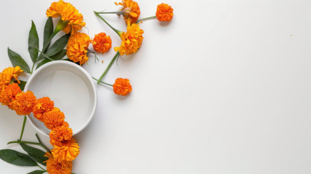 A stunning arrangement of vibrant orange marigold flowers and green leaves encircles a simple white bowl filled with water, creating a serene and artistic display.の素材