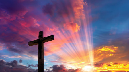 A stunning silhouette of a cross against a vibrant sunset sky filled with colorful clouds and radiant light, evoking feelings of peace and spirituality.の素材