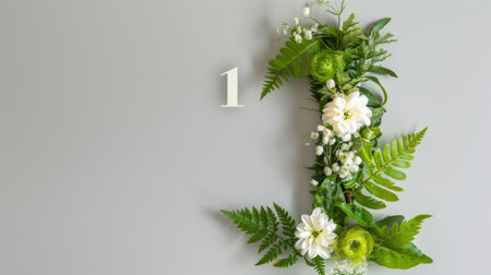 This stunning floral arrangement featuring the number one offers a fresh and elegant touch to any space. Ideal for home decor or event themes, it combines green foliage and white blossoms against a soft gray background, inviting creativity and charm.の素材