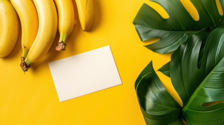 A vibrant flat lay image showcasing fresh bananas alongside tropical green leaves on a bold yellow background. Ideal for wellness and healthy living projects.の素材