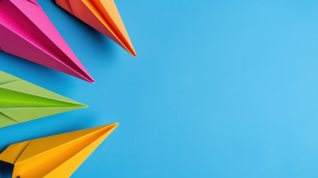 A stunning arrangement of colorful paper airplanes on a vibrant blue background, symbolizing creativity, imagination, and fun activities for children and adults alike.の素材