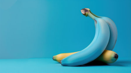 Bright blue and yellow bananas rest creatively on a smooth surface, radiating freshness and vibrancy. Ideal for food-themed projects, this image captures the essence of tropical fruit.の素材