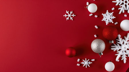 This festive image showcases an artistic arrangement of red and white ornaments alongside white snowflakes on a vibrant red background, perfect for holiday themes.の素材