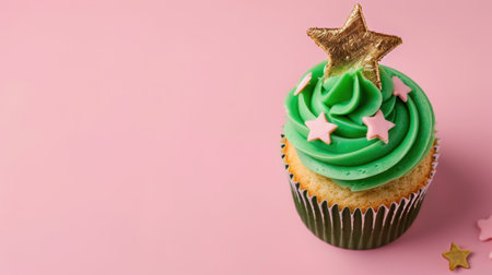This image features a delightful green frosted cupcake topped with a gold star on a pastel pink background, perfect for festive occasions and dessert lovers.の素材