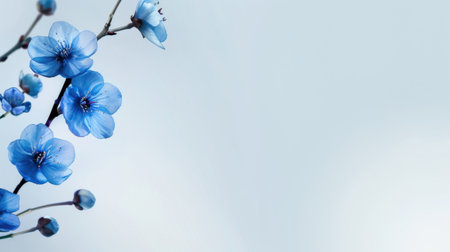 This stunning image captures delicate blue flowers blooming gracefully on a slender branch, set against a soft, ethereal background. The vibrant colors and fine details evoke a sense of tranquility and beauty in nature, perfect for artistic or decorative purposes.の素材