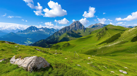 A stunning view of a mountainous landscape showcasing lush green hills and a bright blue sky dotted with fluffy clouds. Perfect for nature lovers.の素材