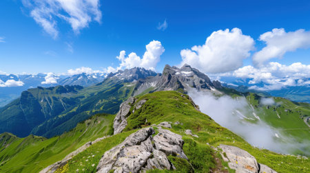 Experience the stunning beauty of majestic mountains under a bright blue sky, with fluffy clouds and lush greenery creating a perfect landscape for nature lovers.の素材