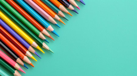A captivating display of wooden colored pencils arranged on a bright aquamarine background, perfect for art enthusiasts and students.の素材