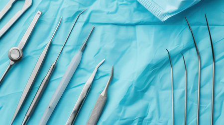 A close-up view featuring various surgical instruments arranged meticulously on blue surgical drapes. The scene conveys a sense of professionalism and hygiene essential for medical practices.の素材