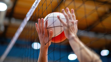 A captivating moment in volleyball as hands reach for a ball near the net, showcasing athleticism and dynamic energy in an indoor gym setting.の素材