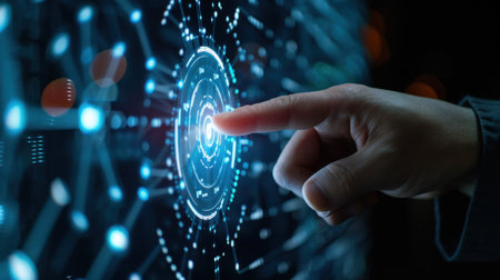 A close-up of a human hand interacting with an advanced digital interface filled with neon light symbols and vibrant technology elements.の素材