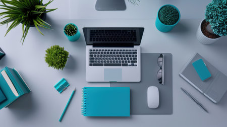 A vibrant office workspace featuring a sleek laptop, assorted plants, and stylish office supplies arranged in turquoise hues, perfect for productivity and inspiration.の素材