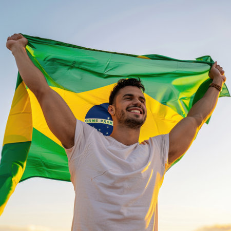 A joyful young man raises a large Brazilian flag, embracing the beauty of sunset. The scene captures emotions of pride and celebration, symbolizing national identity.の素材