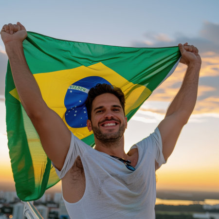 A young man stands against a stunning sunset, joyfully holding a Brazilian flag. This image captures vibrant cultural expression and a sense of national pride.の素材