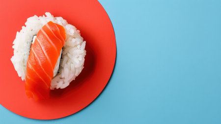 This captivating image features a piece of fresh salmon sushi placed on a striking red plate, set against a soft light blue background, making it ideal for food-related projects.の素材