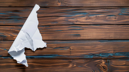 A crumpled white paper sheet rests on a rustic wooden table, showcasing unique textures and colors. This minimalist image evokes creativity and fresh ideas.の素材