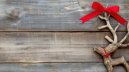 A rustic wooden background featuring a charming reindeer decoration adorned with a vibrant red ribbon, perfect for holiday-themed projects and festive designs.の素材