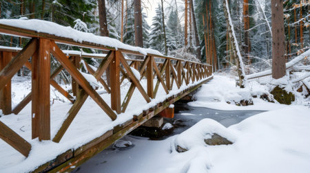A beautiful wooden bridge blanketed in snow, nestled in a serene winter forest. Pine trees surround the scene, creating a tranquil winter landscape.の素材
