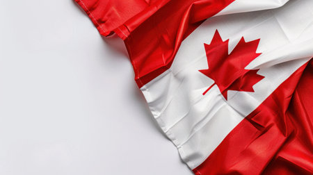A stunning close-up view of the Canadian flag beautifully displayed on a white surface, highlighting the signature red and white colors along with the iconic leaf symbol, representing national pride and identity. The vibrant fabric showcases fine details and elegant design, making it perfect for themes of patriotism, culture, and celebration.の素材