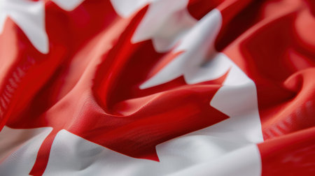 This image showcases a detailed close-up of the Canadian flag, capturing the vibrant red and white colors in a textile format, ideal for national pride themes.の素材