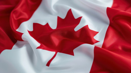 A vibrant Canadian flag gracefully waving, showcasing the iconic red and white colors with a striking maple leaf, embodying national pride and identity.の素材