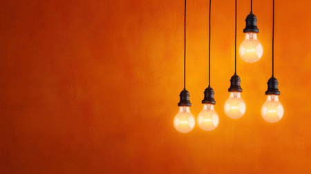 This image features five hanging light bulbs against a vibrant orange wall, creating a warm and inviting atmosphere perfect for modern interior design projects.の素材
