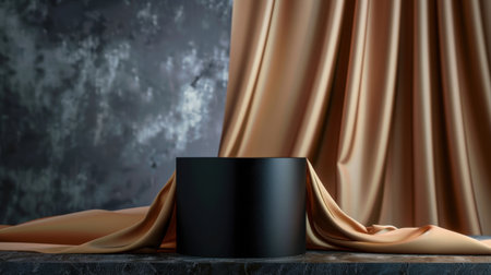 This image features a sleek black cylinder elegantly draped with soft fabric against a textured backdrop, perfect for showcasing luxury and sophistication.の素材