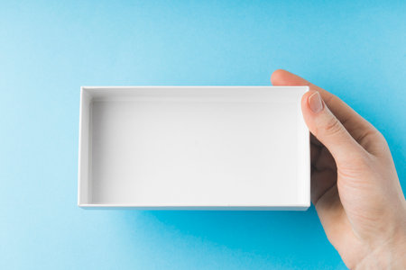 womens hands hold an empty white box, top view,