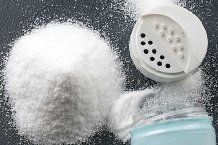 food salt and an open jar with a lid, on the tableの写真素材