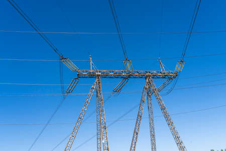 a line of high-voltage wires on a blue sky background
