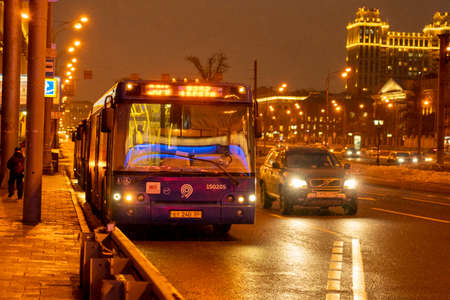 Moscow March 18, 2021 public transport stop in Moscow at night transportation of passengers around the clock Illuminated bus stop in the city center The bus runs through Moscow at nightのeditorial素材