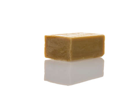 a piece of household soap of 72 percent fat content, highlighted on a white background, reflection. Cleanliness, disinfection and health. Close-up. Natural soap for washing.の写真素材
