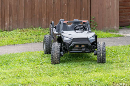 black electric car for children on the grass at home, modern electric car for children, toy car,...