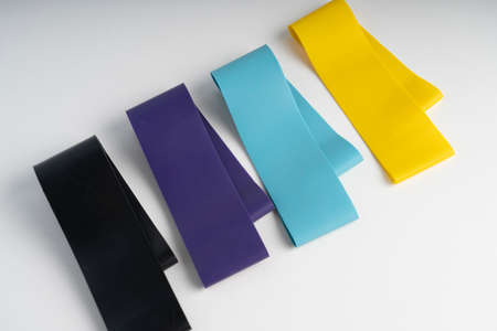 A set of colorful elastic fitness band. Expanders for women and weight loss on white background Flat...