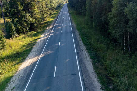 two-lane road in the forest in the summer on aの写真素材