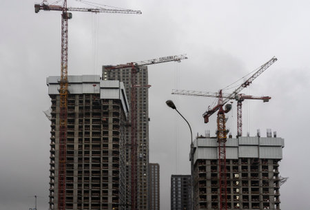 Sunset landscape.Construction cranes and buildingsのeditorial素材