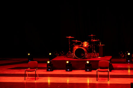 a pre-performance scene in red light with a drum