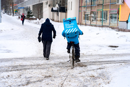 Food delivery in Moscow by bicycle in winter.のeditorial素材